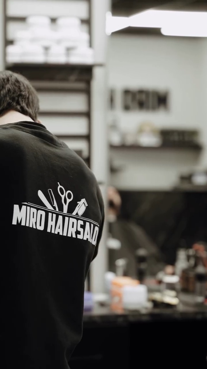 Barber van Miro Hairsalon in een zwart shirt met het logo op de rug